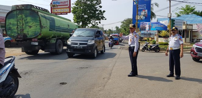 
 Foto Riduan  Caption : Kadishub Lampura Basirun Ali, saat turun bersama anggotanya dalam mengurai kemacetan lalulintas di perempatan jalan Kebun Empat Kotabumi, Minggu(10/6).
 