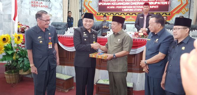 
 Foto Riduan 
Caption : Bupati Lampura Hi. Agung Ilmu Mangkunegara, saat menyarahkan draf LKPj Tahun 2017 kepada Ketua DPRD Hi. Rachmat Hartono, dalam sidang peripurna, Selasa (24/7).
 