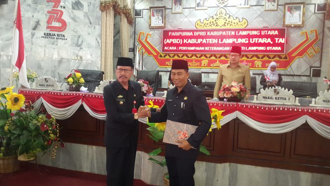 
 Foto RNN
Caption : Yuzar, Assisten I sekretariat Pemkab Lampura, menyerahkan Rancangan APBDP 2018 untuk dilakukan pembahasan kepada Wakil Ketua DPRD Lampura Nurdin Habim, dalam rapat paripurna, Rabu (26/9).  