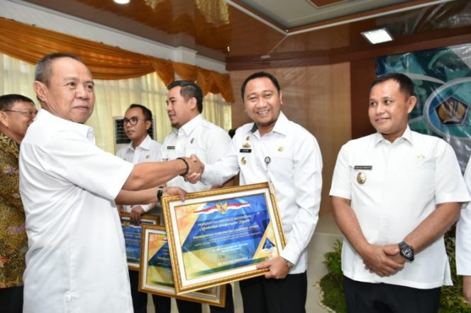 
 Foto Diskominfo Lampura 
Caption : Bupati Lampura Hi. Agung Ilmu Mangkunegara, saat menerima penghargaan WTP, yang diserahkan Wagub Lampung Hi. Bachtiar Basri, Rabu (24/10).