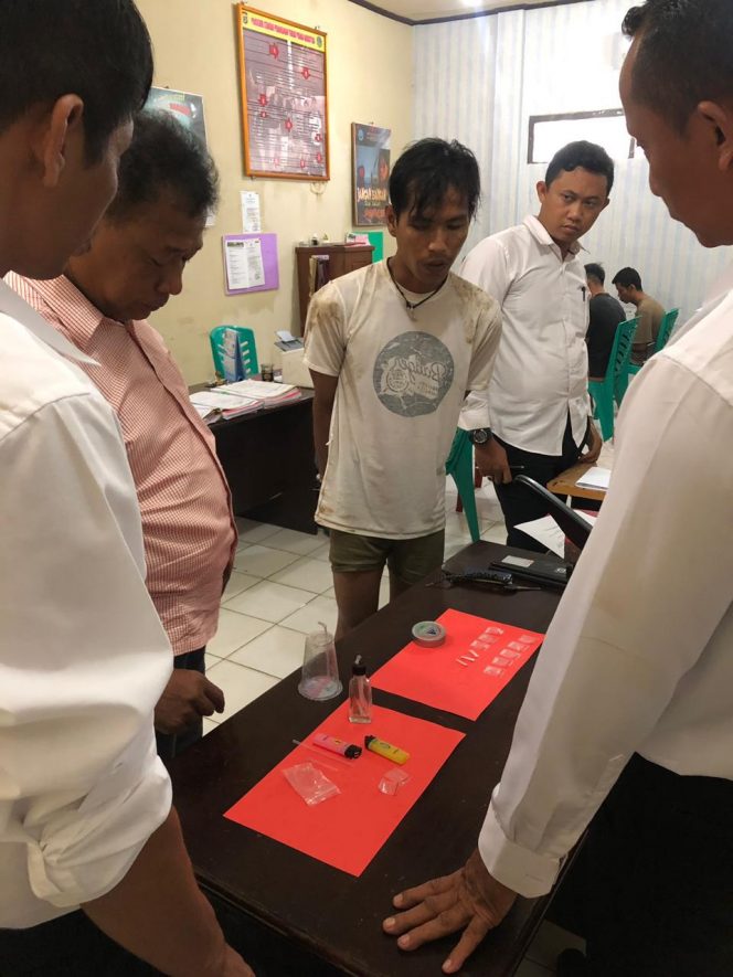 
 Foto : Sat-res Narkoba Polres Lampura
Caption : Arrifai (Kaos Putih) saat menyaksikan sejumlah BB Shabu yang diperlihatkan Polisi kepadanya, foto dibidik Senin (26/11).
