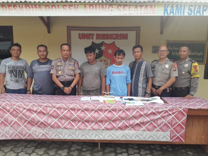 
 Foto : Humas Polsek Abung Selatan
Caption : Kapolsek Abung Selatan AKP Sukimanto saat menunjukkan dua tersangka judi togel online berikut barang buktinya. Foto dibidik di Depan Mapolsek Abung Selatan, Senin (3/12).