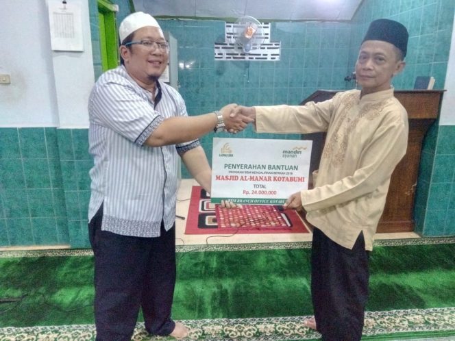 
 caption foto : Branch Manager Bank Syariah Mandiri Kotabumi Arie Anjar Pinardi (kiri) saat menyerahkan bantuan program BMB kepada pengurus masjid Al Manar Kotabumi, Minggu (16/12)