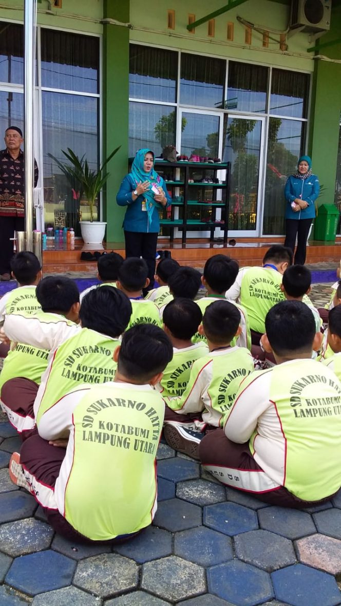 
 Foto IST
Caption : Tampak Plt. Kadisdukcapil Lampura Tien Rostina saat membagikan KIA di SD Soekarno Hatta.
