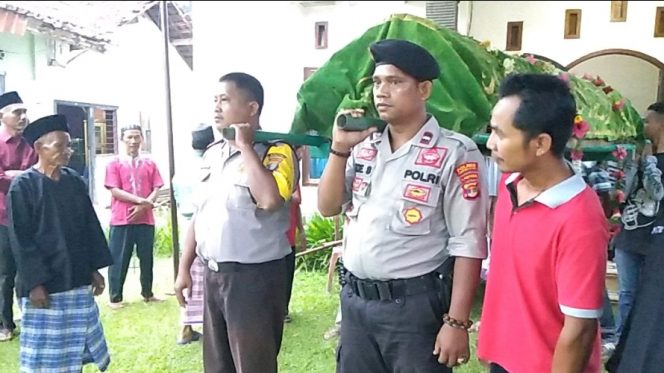 
 Caption Foto : Terlihat petugas kepolisian tengah  membantu masyarakat  dalam prosesi pemakaman. Foto dibidik Kamis (7/2).  