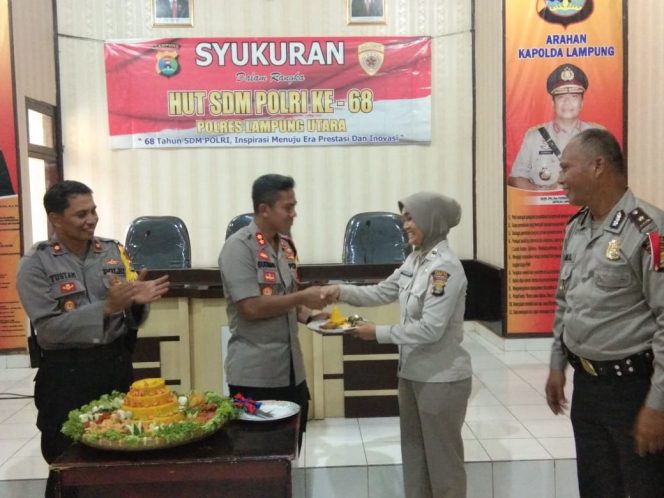 
 Foto : Humas Polres Lampura
Caption :  Kapolres Lampura AKBP Budiman Sulaksono saat menyerahkan potongan tumpeng pertama kepada PNS Polri dalam peringatan HUT SDM Polri, di Ruang Aula Rekonfu Mapolres setempat Minggu (13/3).