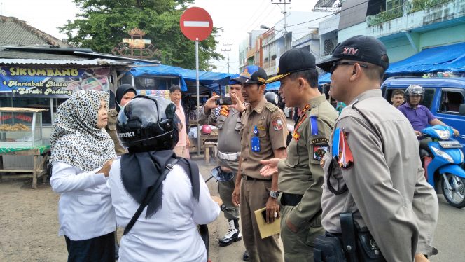 
 Foto cw9 
Caption : Kasat Pol PP Lampura Hi. Pirmansyah, saat memberi arahan dan teguran kepada dua oknum ASN yang kedapatan berkeliaran saat jam kerja di Pasar Dekon Kotabumi, belum lama ini.