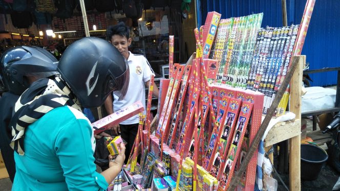 
 Foto cw9
Caption : Salah seorang penjual petasan dan kembang api musiman yang sedang melayani calon pembeli di sekitar pasar dekon Kotabumi, Selasa (7/5).