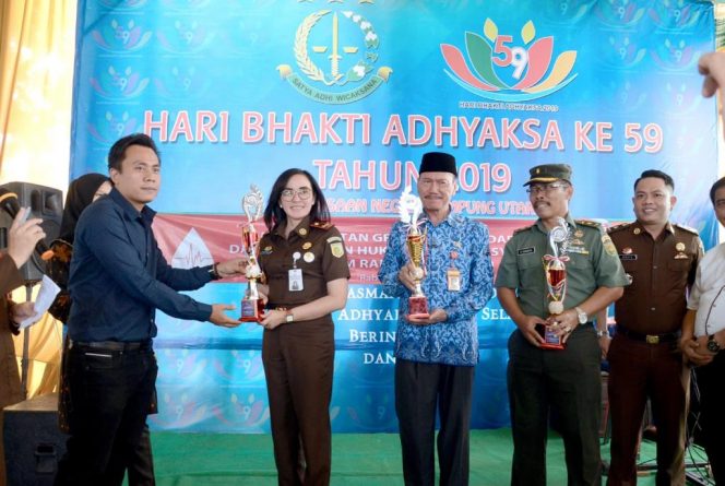 
 Foto Ferdani
Caption : Ketua PWI Lampura Jimi Irawan, selaku juri dalam lomba membuat nasi goreng dalam peringatan HBA ke 59, saat menyerahkan hadiah kepada Kajari Yuliana Sagala, Rabu (17/7).
 