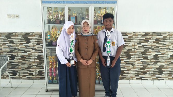 
 foto cw9 :  Caption : Rosmalayati, Wakil Kesiswaan SMPN 2 Kotabumi, beserta siswa-siswi berprestasi asal sekolah tersebut. Foto dibidik, Selasa (17/9).