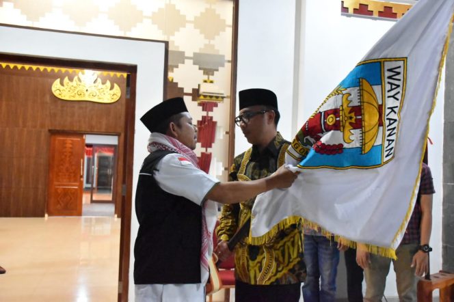 
 Caption foto : Hi.Rohim Sidiq SAg.TPHD Way Kanan menyerahkan bendera rombongan Kepada Bupati Way Kanan sesampainya jamaah haji di rumah dinas Bupati Way Kanan, Selasa (10/9) dinihari.