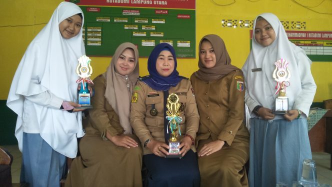 
 Foto cw9
Caption : Kepala SMK 1 Muhamaddiyah Susilawati, bersama jajarannya saat menunjukan piala yang berhasil diraih baru-baru ini.  