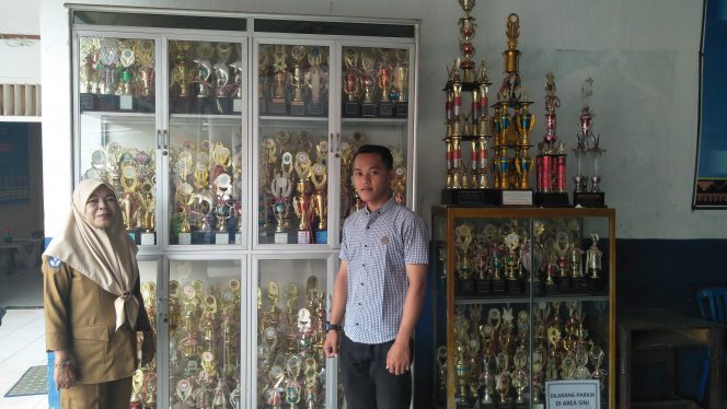 
 Foto cw9
Caption : Indarwati, Kepala SMPN 3 Kotabumi didampingi guru olahraga saat menunjukan sejumlah piala yang berhasil diperoleh sekolah tersebut.