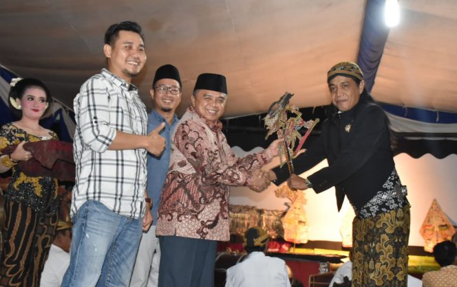 
 Caption foto : Penyerahan wayang oleh Wakil Bupati Waykanan Edward Anthony kepada dalang Ki Toto Irawan dalam pagelaran wayang kulit di Kampung Bumiagung, Kecamatan Bumiagung, Minggu malam (29/9). FOTO HUMAS PEMKAB WAYKANAN