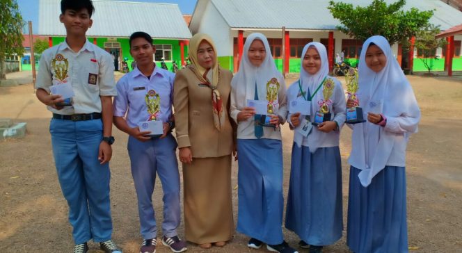 
 Caption : Susilawati, kepala SMK 1 Muhammadiyah Kotabumi, beserta siswa-siswi yang berhasil meraih prestasi seusai menyerahkan piala.
