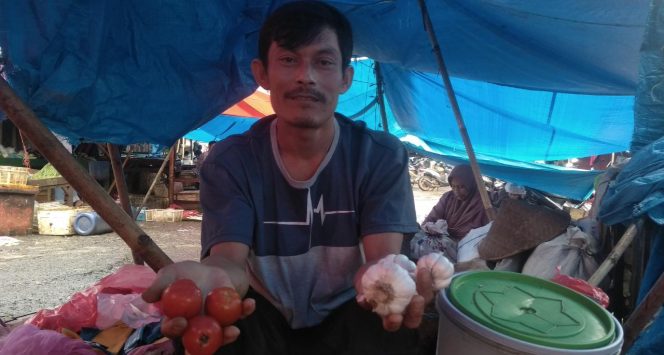 
 Caption foto : Anto Pani (40) pedagang bawang yang mangkal di Pasar Dekon Kotabumi, mengaku lesu. Kenaikan bawang putih yang signifikan membuat omzet penjualannya turun drastis
