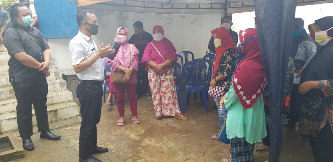 
 caption foto : Ketua DPRD Lampura, Romli, saat menemui masyarakat penerima bantuam BPNT Saldo Nol, di halaman samping Bank Mandiri Kotabumi, Rabu(15/4).