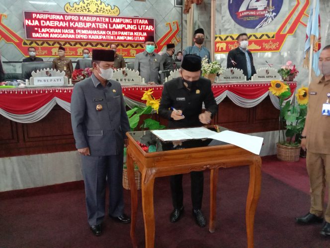 
 caption foto : Ketua DPRD Lampura, Romli bersama Plt Bupati Lampura, Budi Utomo menandatangani nota kesepakatan Raperda Perubahan APBD menjadi Perda Perubahan APBD 2020, dalam rapat paripurna, Rabu (30/9) 
