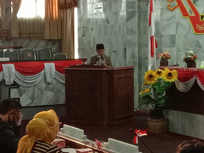 
 caption foto : Plt.Bupati Lampura Budi Utomo, saat menyampaikan jawaban atas pemandangan umum fraksi-fraksi pada Rapat Paripurna DPRD setempat tentang RAPBD Lampura Tahun 2021