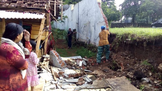 
 caption foto : Inilah pagar tembok kompleks Islamic Center Kotabumi yang roboh dan nyaris menimpa kediaman warga. Tampak puing tembok yang berserakan dan kondisi kediaman Salimah yang hancur.