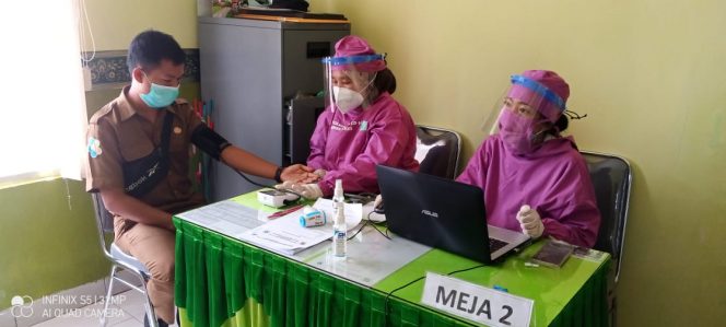 
 caption foto : Nakes Puskesmas Kotabumi II tengah menjalani vaksinasi