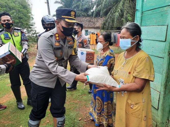 
 caption : Kapolres Lampura AKBP Kurniawan Ismail, menyerahkan sembako pada warga Desa sumber Arum, Kecematan Kotabumi