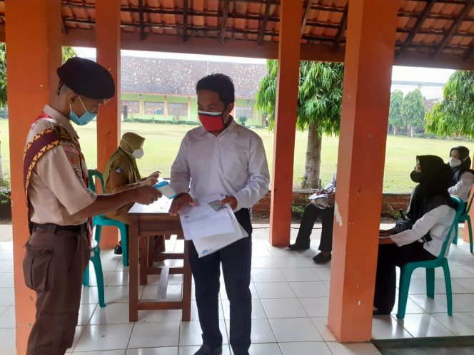 
 Foto IST  Tampak salah satu peserta sebelum masuk ke ruangan di periksa suhu tubuhnya terlebih dahulu, Senin(13/9).  