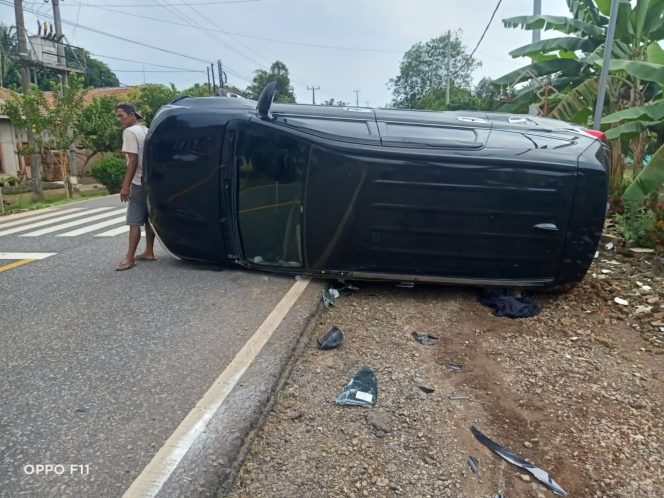 
 caption : Minibus warna hitam yang terguling setelah menghantam sedan dari arah berlawanan
