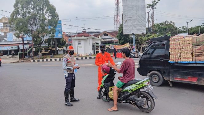 
 Foto IST  caption : Tampak para petugas Satgasus Covid-19 saat membagikan masker kepada pengguna jalan yang tidak memakai masker di Tugu Payan Mas Kotabumi, Rabu(13/10).