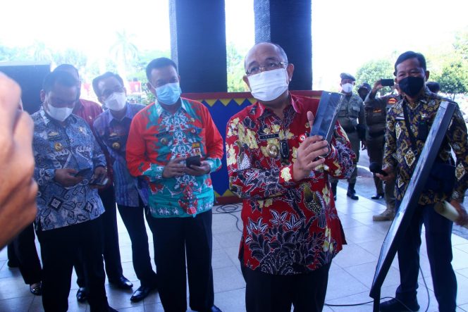 
 Foto Diskominfo Lampura  Sekkab H. Lekok saat menunjukkan aplikasi Scan QR di pintu masuk Pemkab Lampura, Kamis (21/10).  