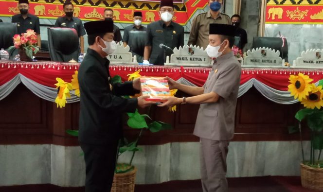
 Foto 
Caption : Bupati Hi. Budi Utomo, saat menyerahkan RABPD 2022 kepada Ketua DPRD Lampura Romli, untuk dibahas ditingkat panitia kerja(Panja) Badan Anggaran(Banang).
