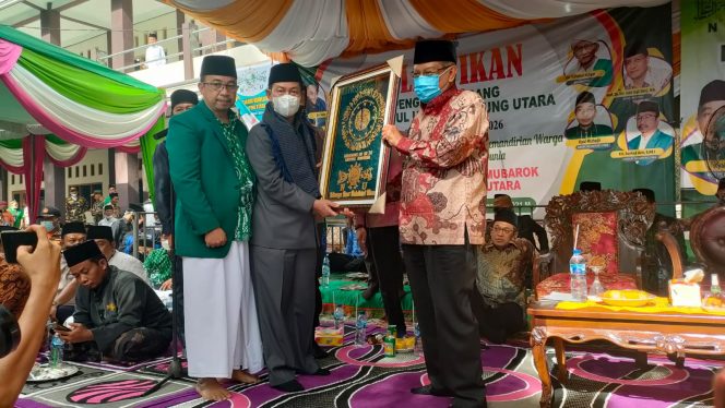 
 caption : Bupati Lampung Utara, memberikan cindera mata pada  Ketua PBNU KH Said Akil Siradj dalam acara Pelantikan PC NU Lampura masa khidmat 2021 - 2026, di Pondok Pesantren Al - Mubaroq Kecamatan Sungkai Utara, Senin(29/11).
