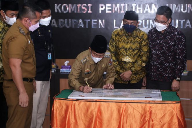 
 Caption : Bupati Lampura H. Budi Utomo saat mendatangani naskah hibah tanah dan gedung kantor KPU Lampura  Selasa (9/11).