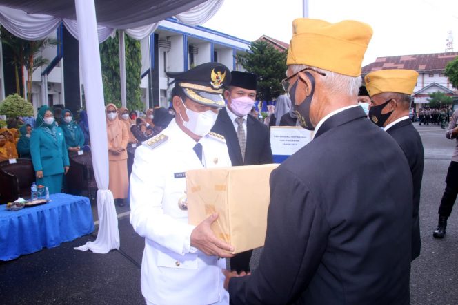 
 caption : Bupati Lampura saat memberikan cindera mata kepada para Pahlawan Kemerdekaan(Veteran) saat Upacara Peringatan Hari Pahlawan, Rabu(10/11).