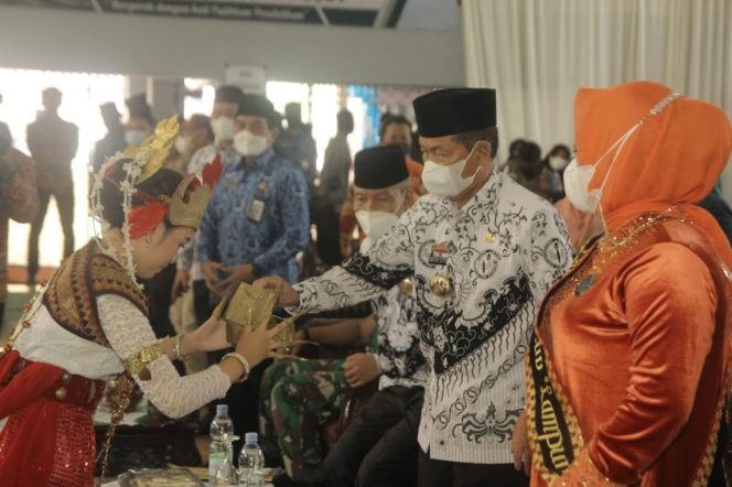 
 caption : Bupati Lampura menerima sekapur sirih pada peringatan Hari Guru Nasional dan Launching Sekolah Digital di GOR Sukung Kotabumi, Kamis (25/11).
