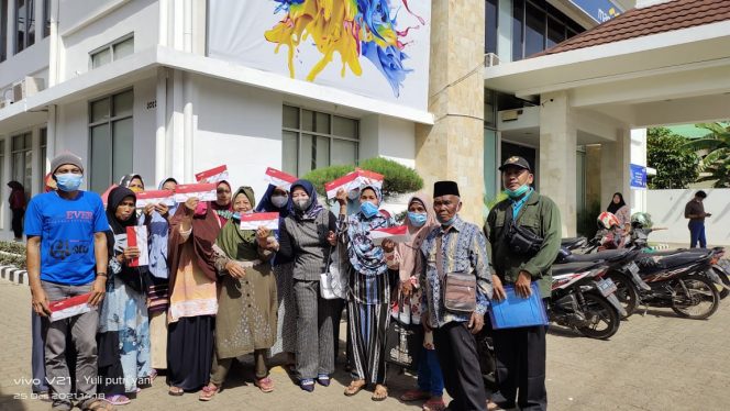 
 Foto IST 
Caption : Yuli(35) Pendamping Bansos Program Sembako Kecamatan Bungamayang, saat mendampingi KPM dalam pengambilan KKS tambahan PPKM 2021 di Bank Mandiri, Sabtu(25/12).
