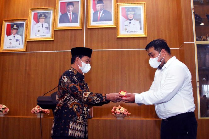 
 Foto Diskominfo Lampura  Bupati Lampura H. Budi Utomo saat menyerahkan penghargaan bintang kepada perwakilan keluarga besar dari Almarhumah dr. Sri Haryati di Rumdis Bupati,Kamis(23/12).  