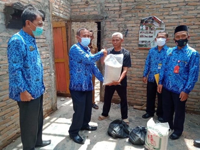 
 Foto IST  Kabid Rekontruksi dan Rehabilitasi Kasim saat menyerahkan bantuan Sembako kepada korban yang rumahnya tersambar petir, Senin (17/1).  