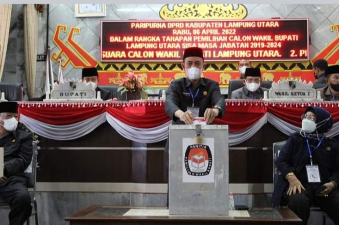 
 caption :  Ketua DPRD Lampura Romli,  memasukan kertas suara yang telah dicoblosnya kedalam kotak suara pada pemungutan suara Pilwabup Lampura.
