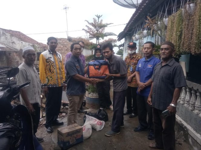 
 caption : Tampak korban kebakaran Iswandi saat menerima bantuan dari BPBD Lampura.
