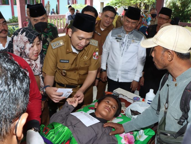 
 Wabup Lampura Ardian Saputra didampingi Camat Kasim saat memberikan tanda cinta kasih kepada anak-anak yang mengikuti Sunatan Masal di Abung Tengah, Selasa (14/6). Foto  Bagian Protokol Lampura  