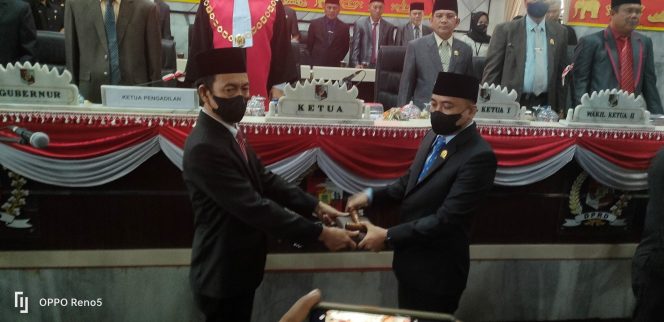 
 Foto Riduan/Radar Kotabumi  Caption : Eks Ketua DPRD Lampura Romli, S.Ag., saat menyerahkan palu sidang kepada Wansori, S.H, Senin(1/8).  