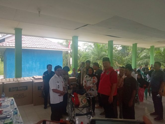 
 caption : Anggota DPR RI, I Komang koheri, Kadis sosial Lampura, Eka Dharma Tohir dan Camat Kotabumi Selatan Dedi Nurman, memberikan bantuan ATENSI di kecamatan Kotabumi Selatan, Rabu (26/10)  
