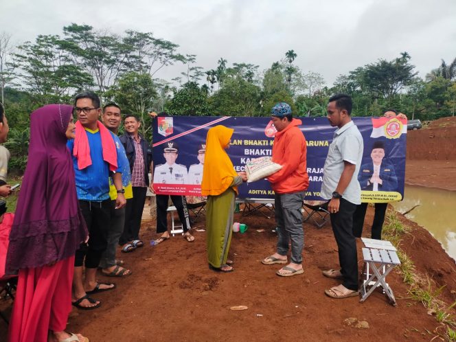 
 Ketua Karang Taruna Kabupaten Lampung Utara, Hi.M. Erwinsyah, saat membagikan sembako, sebagai penutup agenda Temu Karya Karang Taruna di Kecamatan Tanjungraja, Sabtu(8/10). Foto IST ----