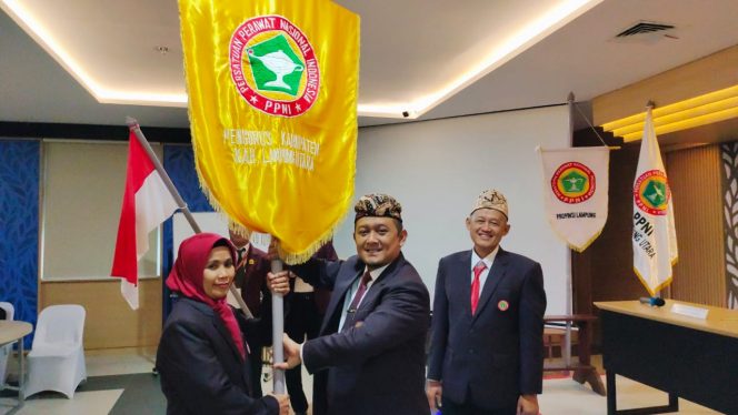 
 Ketua DPW PPNI Lampung Puji Sartono, saat menyerahkan bendera petaka sebagai panji PPNI kepada Ketua DPD PPNI terpilih Ns. Eva Karmila Sari,  untuk dikibarkan di seluruh wilayah Lampung Utara. Foto IST -------