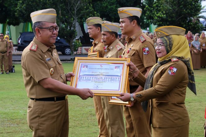 
 Sekretaris Kabupaten Lampung Utara Hi. Lekok saat memberikan penghargaan kepada salah satu dinas yang patuh, kemarin(12/12). Foto Ria Radar Kotabumi ------
