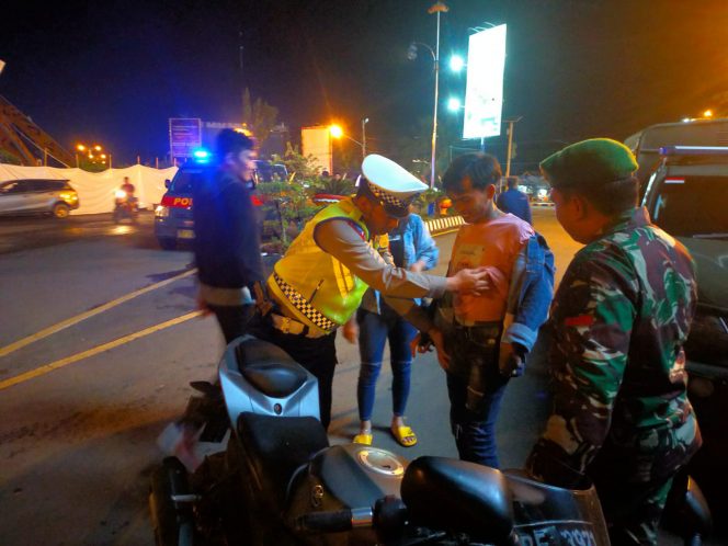 
 Anggota Polres Lampura dan TNI dari makodim 0412/LU dan Satuan Pol – PP Pemkab Lampura, saat melakukan razia menjelang malam tahun baru di tugu Payan Mas Kotabumi. Foto IST ----  