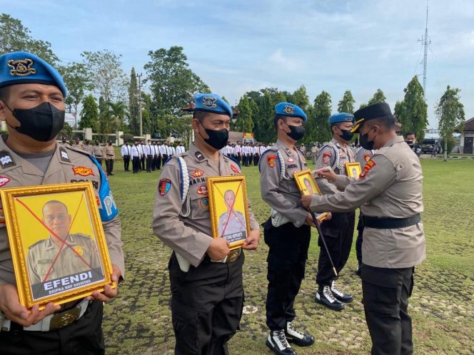 
 Kapolres Lampura AKBP Kurniawan Ismail saat melakukan PTDH terhadap lima anggotanya dengan mencoret silang menggunakan tinta merah pada foto wajah mereka, Senin(12/12). Foto IST ------