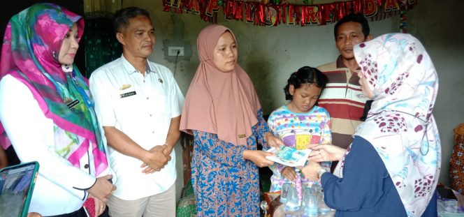 
 Kabid Rehabilitasi Sosial Dinsos Lampura Gria Suryana Adhitama saat mendampingi tim Kemensos memberikan bantuan ke Anisa. Foto IST -----