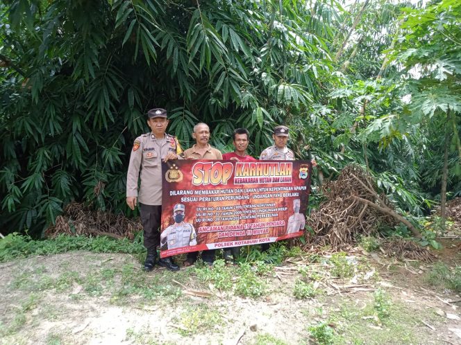 
 Personil Polsek Kotabumi bersama masyarakat saat membentangkan spanduk Stop Karhutlah, dalam rangka sosialisasi munculnya bencana kabut asap. Foto Dok Polsek Kotabumi -----